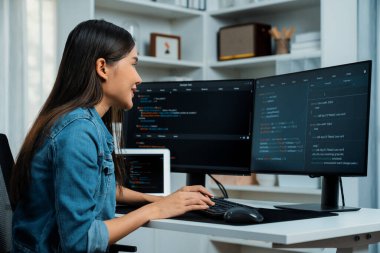 İnternet sitesi uygulamasının kodlama verileriyle birlikte online bilgi yazarak kot gömlek giyen genç Asyalı geliştirici. Güvenlik analizi ile çevrili iki ekran. Taktik.