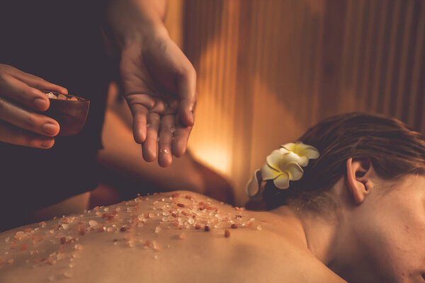 Крупным планом пару клиентов, имеющих пилинг лечение в роскошном спа-салоне с теплой свечи окружающей среды. Косметическое лечение бальзамическим скрабом в Health spa scrub. Quiescent