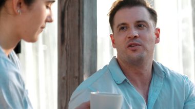 Güzel, orta yaşlı bir çift mutlu bir şekilde güzel olaylardan ya da terasta haberlerden bahsediyorlar rahatlayıp sohbet ediyorlar. Neşeli anne ve babanın mutlu bir ilişkileri ve güçlü bir aile bağları vardır. Uyumsuzluk.