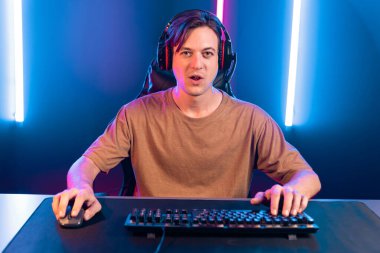 Kazanmak için çevrimiçi oyun oynayan akıllı flama makinesinin sunucu kanalı, neon ışıklı odada seçilen takım yarışması için izleyicilerle birlikte canlı yayında canlı yayında kulaklık takıyor. Bireysel.