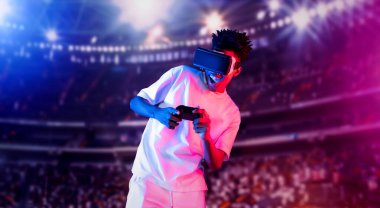 Yetişkinlerin elinde joystickle VR gözlükleri varken stadyumda arka planda bulanık oyunlar oynamaktan zevk alıyorlar. Afrikalı adam kontrol etmeyi ve artırılmış gerçeklik teknolojisini kullanmayı seviyor. Yaratıcılık.