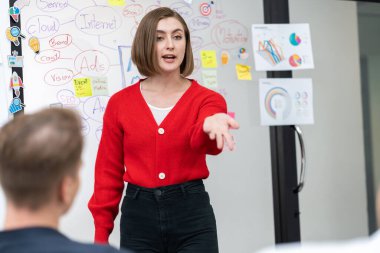 Profesyonel çekici kadın lider, modern iş toplantı odasında beyin fırtınası zihin haritalama istatistikleri ve renkli yapışkan notlar kullanarak yaratıcı pazarlama planını sunuyor. Tertemiz..
