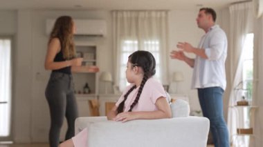 Sinirli ve mutsuz genç bir kız oturma odasında ebeveyninin tartışması yüzünden gerginliğin ortasında kanepede oturuyor. Sağlıksız ev hayatı ve travmatik çocukluk depresyona dönüşür.