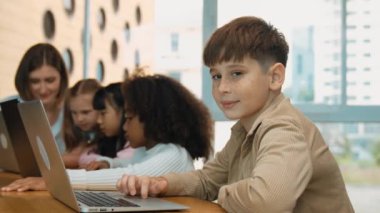 Çocuk BTMM Teknoloji dersinde çok kültürlü bir arkadaşıyla kameraya bakıyor. Mühendislik kodları ve bulanık geçmişi olan programlama sistemi üzerine çok kültürlü bir öğrenci çalışması. Etkinlik.