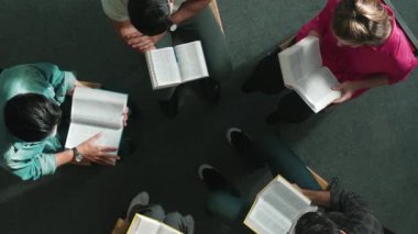 İncil 'i okuyup, kucağında İncil' le daireler çizerek otururken en tepeden aşağı dua manzarası. İnanç, güven ve umut ve sükunetle çalışırken farklı insanların kitaba bakışları. Sempozyum.