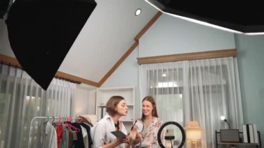 Etkilenen iki ortak canlı yayında video görüntülerini çekiyor makyaj malzemesi prim sosyal medya veya blog. Kozmetik stüdyosu ışıklandırmalı mutlu genç kız çevrimiçi pazarlama oturumu yayını için..