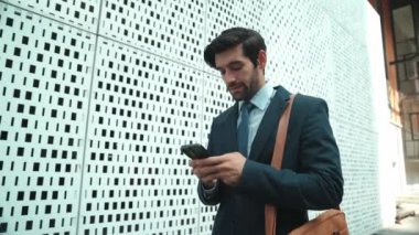 Akıllı iş adamı iş yatırımları için ekibi aramak için telefonu kullanıyor. İş planı, pazarlama stratejisi ya da çalışma hakkında konuşmak için akıllı telefonla konuşurken sokakta yürüyen bir yönetici. Sevinçli..