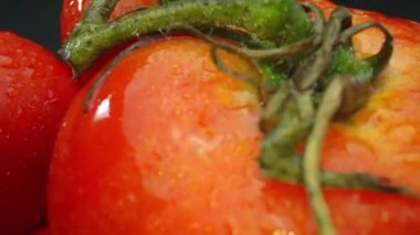 Makrografi, ahşap bir sepete yerleştirilmiş domatesler dramatik bir siyah arka plana karşı sergileniyor. Her yakın çekim domateslerin zengin renklerini ve dokularını yakalar. Geliştirilebilir.