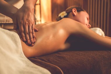 Beyaz kadın müşteri stres önleyici spa masajının keyfini çıkarıyor ve lüks otel ya da otelde sıcak mum ışığında güzellik teniyle eğleniyor. Sessiz.