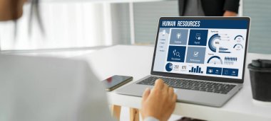 Human resources management software on computer screen helping human resources employee to manage recruitment, payroll, staff searching and KPI evaluation snugly