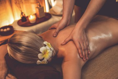 Yakından kadın müşteri strese karşı spa masajını rahatlatıyor ve lüks otel ya da otelde sıcak mum ışığında güzellik teniyle eğleniyor. Sessiz.