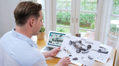 Car design engineer analyze car prototype for automobile business at home office. Automotive engineering designer carefully analyze, finding flaws and improvement for car design with laptop Synchronos clipart