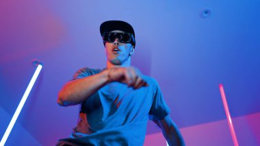 Beyaz dansçının gösterişli gözlükler taktığı ve break dans yaptığı alçak açılı kamera. Çekici adam kendinden emin bir şekilde kameraya bakarken enerjik bir performans ve hareket gösterdi. Mutluluk.