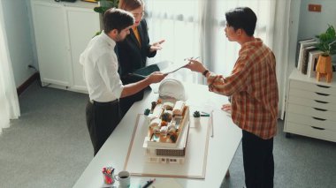 Yöneticinin ev modelini göstermesi ve bina tasarımını açıklaması. Tablet ev planı sergilenirken iç yapı hakkında beyin fırtınası yapan mimar mühendisinin hava görüntüsü. Hizalama.