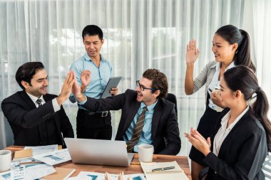 Bir grup mutlu iş adamı beşlik bir jest ve başarılı bir takım çalışması yapıyor. Çeşitli yarış bürosu çalışanları şirket ofisinde pazarlama planlamasında ilerleme kaydettikten sonra kutlama yapıyorlar. Çok titiz.