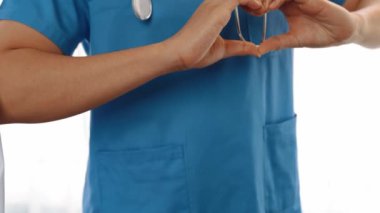 Profesyonel sağlık personeli kuyrukta bekleyip, birlikte el kaldırarak sağlık hizmetleri ve hastanedeki doktor liderliğini sembolize ediyorlar. Takım çalışması başarılı tedaviye yol açar. Düşük hareket. Katı.