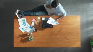 Bacaklarınızı masaya koyarken, gevşemiş iş adamının ekiple telefonda konuşma süresi doldu. Finansal grafiğe bakarken, pazarlama stratejisi hakkında iş arkadaşlarıyla konuşan ve arayan bir yönetici. Cemaat.