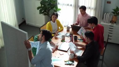 Çekici iş adamlarının en iyi görüşü pazarlama planını sunarken, çeşitli yatırımcılar yaratıcı fikirleri dinliyor ve finansal istatistik belgelerini okuyorlar. Toplantıda fikir paylaşan bir grup insan. Cemaat.