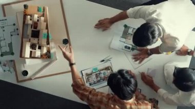 Tasarımcının modelini incelerken inşaat hakkında tartışması zaman aşımı. Toplantı masasında konuşurken ve yazarken fikri açıklayan mimar mühendisinin üst görüşü. Hizalama.