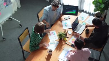 Proje yöneticisinin üst görünümü toplantıda yatırımcılara mali grafik sunuyor. Profesyonel pazarlama ekibi dizüstü bilgisayardan finansal istatistiklere bakarken finansal fikir üretiyor. Cemaat.
