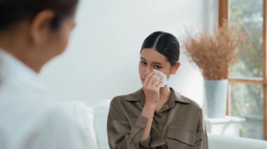 Psikologla ruh sağlığı terapisi gören üzgün travma sonrası stres bozukluğu olan bir kadın. Yaşam sonrası depresyon veya keder. Hayal kırıklığına uğramış genç bir kadın klinikteki duygular hakkında Vivancy psikoloğuyla konuşuyor.