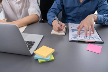 Çeşitli ofis çalışanlarından oluşan bir grup, ofis çalışma alanına yapışkan bir notla stratejik iş pazarlama planlaması üzerine beyin fırtınası yapıyor. İş yerinde olumlu ve verimli bir takım çalışması. Tedbirli.