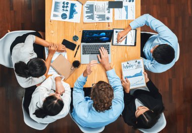 Panorama üst düzey iş analist grubu toplantı masasındaki finansal veri raporunu analiz ediyor. İş zekası analizine göre çizelge ve grafik paneli. Çok titiz.