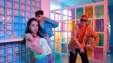 Değişik takımlarla dans ederken süslü gözlük takan yakışıklı hippi serbest stil müzikle mutlulukla dans ediyor. Beyaz hipster kulüpte parlak neon ışıkta sokak dansı yapıyor. Mutluluk.