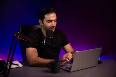 Yayıncı, fanclub dinleyicisiyle mikrofon kullanarak konuşuyor. Mor neon ışıklı modern stüdyoda yaratıcı olumlu düşünce konseptiyle canlı yayında finansal sorunları tartışıyor. Tahmin et..