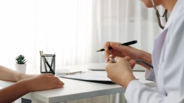 Hasta klinikte ya da hastane ofisinde doktor randevusuna gidiyor. Hastaların risk faktörünü tespit etmek için nabzını ölçmek için steteskopla doktor muayenesi ve teşhis semptomları. Ağır çekim. Katı.