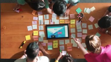 Tablet kablo prototipine bakarken, web tasarımı hakkında beyin fırtınası yapan ve planlayan programcıların tepeden tırnağa görüntüsü. Yetenekli müteahhit takımının dijital uygulamadan bahseden hava görüşü. Sempozyum.
