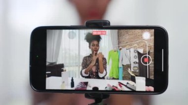 Arka görüş telefon ekranı kadın nüfuzu kaydedicisi canlı yayın yapan video bloğu gözden geçirme makyaj kritik sosyal medya veya blog. Çevrimiçi pazarlama yayını için kozmetik ürünleri olan genç bir kız.