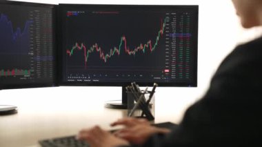 Menkul kıymetler borsası pazarlamasını inceleyen borsa yatırımcıları, zarar ve kazanç için mum bar fiyatlarını analiz eden monitörlere bakıyor. Filizlenen