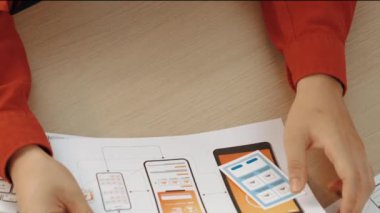 Mobil uygulama için kullanıcı arayüzü prototipi ya da masadaki program modeliyle birlikte web sitesi planlaması yapan bir şirket çalışanı. UX UI tasarımcısı kullanıcı dostu arayüz planını dikkate alır. Sinerjik