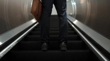 Yürüyen merdivenlerde duran zeki profesyonel iş adamının bacağı. Yetenekli proje yöneticisi terfi alıyor, yeteneğini arttırıyor, yükseltiyor, yeni bir pozisyon alıyor. Merkez. Bacağa odaklan. Sevinçli..