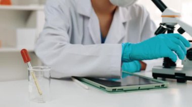 Laboratuvar kimya araştırmacısı mikroskop kullanarak yeni ilaç ya da tedavi geliştirir. Laboratuvar mikrobiyoloji ekipmanları ile bilimsel uzmanlık ile sağlık hizmetlerinin teknolojik gelişimi. Ağır çekim. Katı.