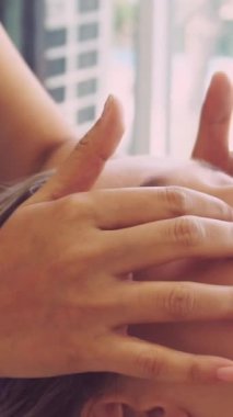 Lüks bir spa merkezinde masaj terapisti tarafından yüz masajı ve spa tedavisi için kaplıcaya uzanmış rahat bir kadın. Sağlık, stres atma ve gençleştirme kavramı.