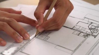 Ölçüm aracı ve kalem el kullanan akıllı mimar veya akıllı mühendisin videosu mimari ofisteki inşaat hatasızlığı için ayrıntılı bir tasarım hazırladı. Eline odaklan. - Yakın çekim. Tanımlama.