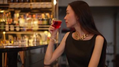 Cosmopolitan kırmızı kokteylinde tek başına güzel bir şekilde oturup arkadaşlarınızı ya da Bokeh 'te bir çifti beklemek cuma gecesi barda ve restoranda lüks bir içki tezgahı yakmak. Vinosity.