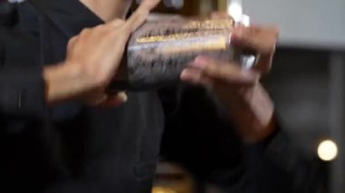 Kapalı Asyalı barmenin sallaması, tüm içecekleri karıştırdı alkol ve şurup tadı ile karıştırıcı sunumu, lüks gece klübünde gece hayatı karışımı sergileniyor. Vinosity.