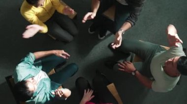 Yukarıdan aşağıya çeşitli iş adamlarının havadan görünüşü birlikte otururken bileklerini tutuyor. Sadık dualar el ele tutuşur. Takım çalışmasını, birliği, birlikteliği temsil etti. Sempozyum.