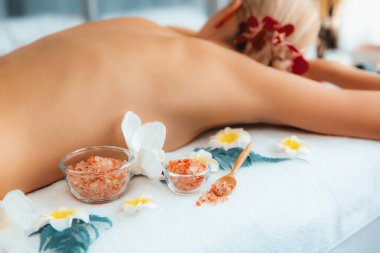 Lüks spa salonlarında sıcak mum ışığında cilt bakımı yaptıran kadın müşteri. Sağlık Spa vücut fırçasında tuz temizleme güzellik tedavisi. Sessiz.
