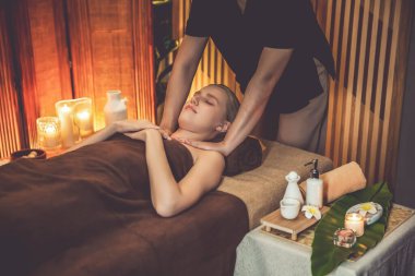 Beyaz kadın müşteri stres önleyici spa masajının keyfini çıkarıyor ve lüks otel ya da otelde sıcak mum ışığında güzellik teniyle eğleniyor. Sessiz.