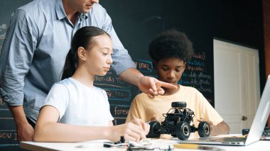 Kafkas öğretmeni elektrikli aletten bahsederken öğrenci de elektronik ekipmanlarla robot modelini tamir ediyor. Çeşitli akademik çocuklar ana kurul yapısını öğreniyor. Öğretim.