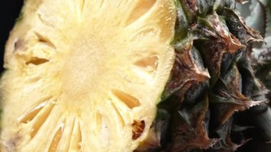 Taze ananas kesiminin makrografisi, parlak siyah bir arka planda ortaya çıkıyor. Her yakın çekim ananasın karmaşık detaylarını ve dokularını yakalar. Kapatın. Geliştirilebilir.