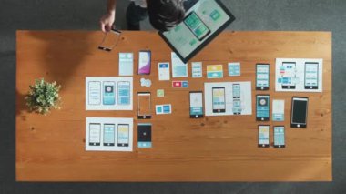 Cep telefonu arayüzü ya da yazılım programı için simge seçerken tablet tutan yazılım geliştiricisinin en üstteki görünümü. Kablo prototipi geliştirmek için Ux Ui tasarımı kullanarak başla. Cemaat.