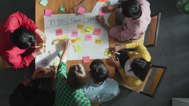 Renkli yapışkan notlarda pazarlama ve planlama stratejisi yazarken insanların yazma ve çalışma tahtası oluşturma konusunda üst düzey bir bakış açısı. Akıllı takım Kanaban tahtasını kullanarak iş performansını yönetir. Cemaat.