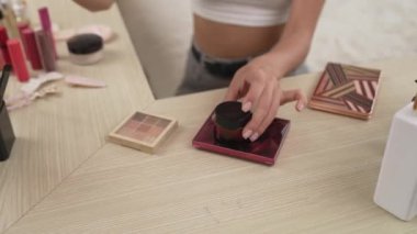 Sosyal medya için güzellik ve kozmetik video içeriği hazırlayan genç bir kadın. Güzellik blogcusu kameraya gülümserken seyircilere ve takipçilere güzellik bakımını gösteriyor. Düzenle