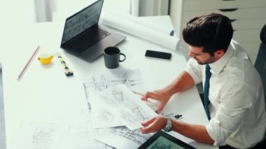 Ofiste dizüstü bilgisayar tasarımı kullanan mimar mühendisi, planlama ve ekipman dağınıklığı ile toplantı masasında otururken. Projede çalışan yetenekli inşaat mühendisi. Hizalama.