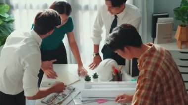 Akıllı mimar ya da inşaat mühendisi bina yapısı fikrini not edip plana yapıştırıyor. Yöneticinin çeşitli meslektaşları ve ev planlarıyla birlikte çalıştığı hava görüşü. Hizalama.